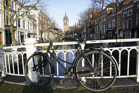 在Delft的运河前面骑自行车图片