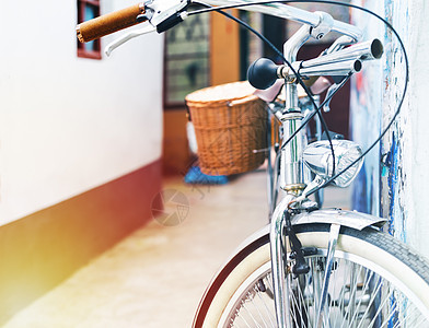 古老的自行车泊车靠在房屋墙壁上人行道运输倾斜街道自由厂房工业潮人反射车轮图片