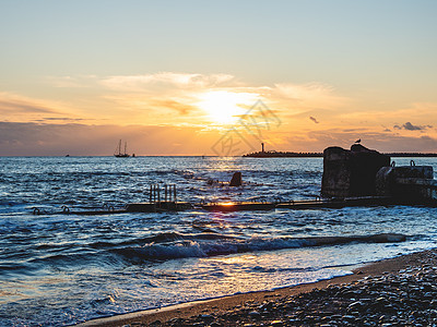 俄罗斯索契黑海的美丽日落 岩石上的海鸥剪影和宁静的海浪海滩石头蓝色航行天空海景阳光地平线灯塔海岸背景图片