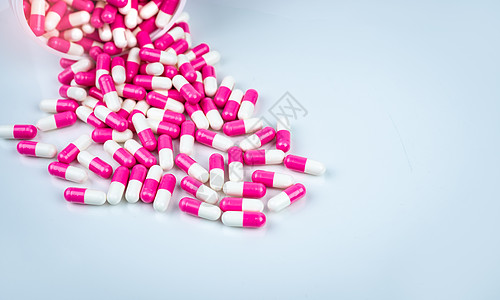 从白色塑料机器人溢出的粉色和白色胶囊药丸药片包装禁忌症药品止痛药生产医院青霉素瓶子制药图片