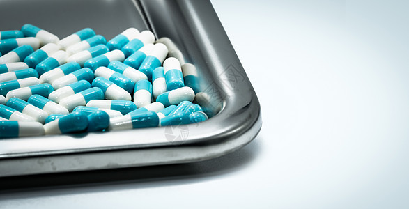 不锈钢药物托盘上的蓝白色胶囊药丸 药房图片