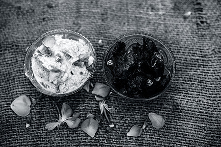 流行的印度 ampamp 的特写镜头透明玻璃碗中的亚洲冬季甜点 即或日期甜点 棕色表面上有生日期和一些玫瑰花瓣午餐食物苏记酥油水图片