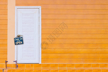 白色木制门和橙色墙 上面有旧的锈金属板广告牌仪式庆典横幅企业家零售建筑商业创业店铺图片