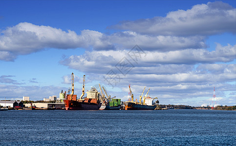 蓝色停靠码头的三艘货船图片