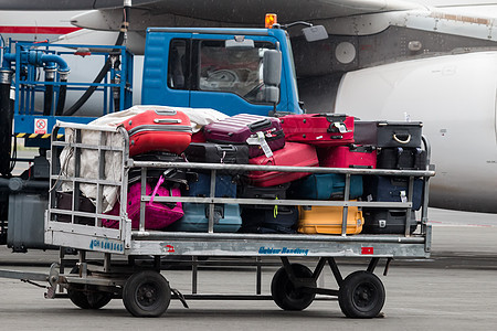马其顿机场跑道上的行李车 一个下雨日以及安全平台货物航班大车机场交通飞机场车辆喷射图片