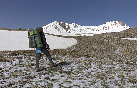 游客从山坡上爬到雪顶顶顶峰荒野女孩天空探险家登山者远足登山路线旅游男人背景图片