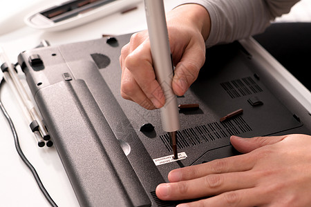 妇女用螺丝驱动器修理笔记本电脑后没有保修硬件螺丝刀维修技术电气技术员服务女性白色母板图片