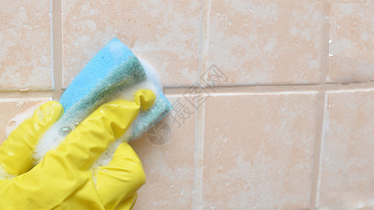 一个穿黄色防护手套的男人在浴室里 洗了一件脏陶瓷瓷砖 家庭工作横幅图片