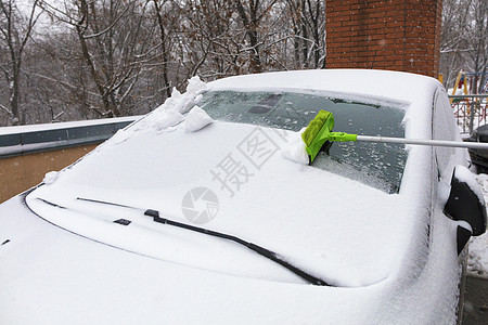 从你车挡风玻璃上用长的刷子扫雪图片