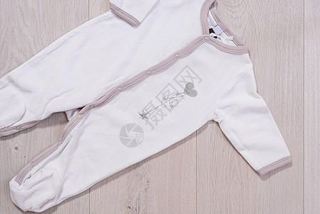 婴儿衣概念 木制男女孩的白色和灰色西装;图片