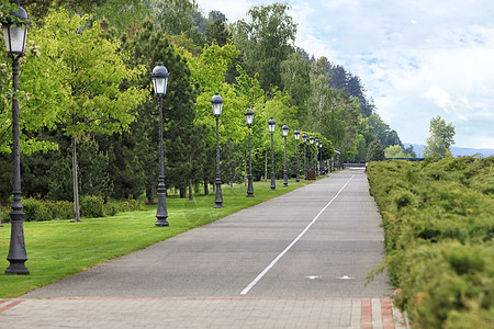 穿过公园的直柏油路和自行车道 有许多美丽的垂直复古灯图片