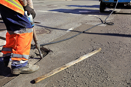 工人在道路建设中清除了一块沥青和一台充气大锤施工建筑工人摄影维修男人电钻碎石劳动职场构造图片