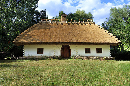 乌克兰老旧传统农村住房 花园内有高铁屋顶和电网围栏蓝色木头房子国家小屋天空历史稻草乡村旅行图片