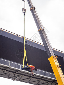 建筑工地起重机正在卸下一个领头的广告招牌屏幕维修途径营销海报展示木板城市商业监视器背景