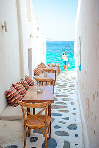 米科诺斯岛一家典型的希腊户外咖啡馆的带枕头的长椅 享有基克拉迪群岛的壮丽海景餐厅街道椅子酒吧石头蓝色游客城市旅游粉饰图片