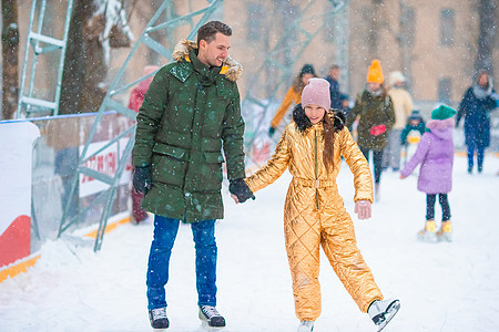 小爸爸和可爱的小女孩 玩滑冰室外溜冰教育手套闲暇男性喜悦童年父母运动娱乐孩子图片