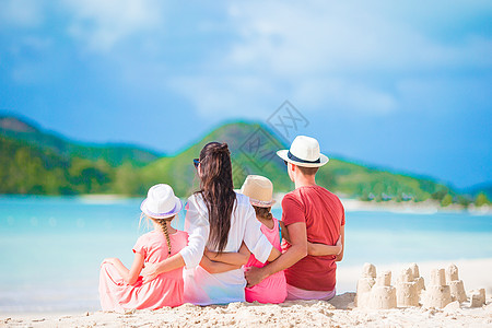 四个家庭在热带白沙滩建沙丘城堡玩具海岸快乐孩子母亲游泳衣支撑海岸线假期父亲图片