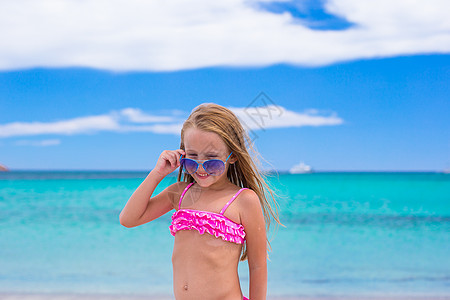 可爱的小女孩在度假期间 在热带海滩玩得开心假期女儿自由女孩海洋支撑太阳镜童年帽子孩子图片