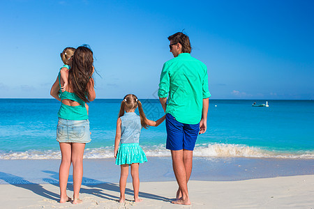 年轻快乐的家庭和两个孩子在暑假喜悦女士假期海滩父母男人女儿孩子们母亲阳光图片