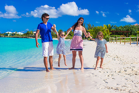 年轻快乐的家庭和两个孩子在暑假女儿海滩热带男性父母姐姐孩子们母亲阳光情调图片