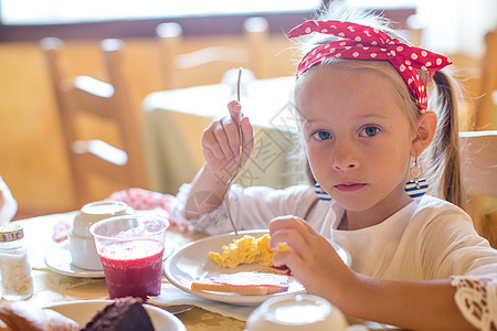 可爱的小女孩在餐厅吃早餐了桌子童年食物微笑孩子小吃快乐假期果汁咖啡店图片