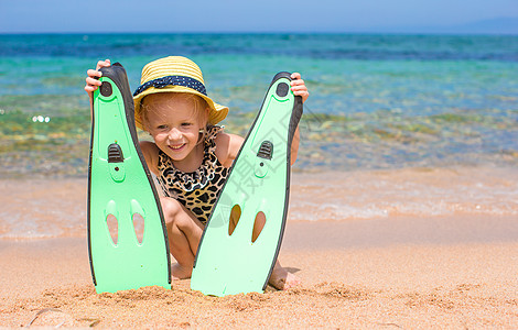 小女孩带脚鞋和护目镜 在沙滩上打鼻涕潜水说谎面具手势运动活动液体太阳脚蹼热带图片