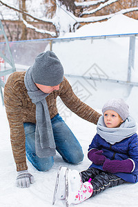 可爱的小女孩和快乐的父亲 在户外滑冰溜冰数字男性家庭学习女孩爸爸溜冰场手套教育教学图片
