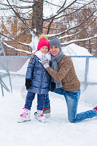 在户外滑冰溜冰场上快乐的一家人训练男性数字爱好帮助小姑娘童年溜冰者生活方式孩子图片