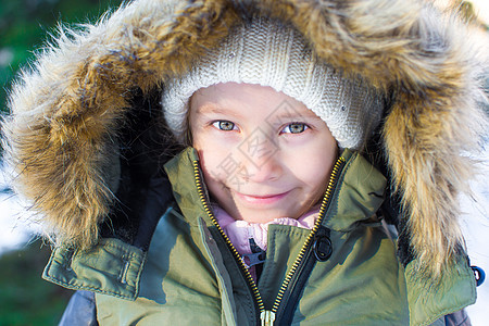 在阳光明媚的冬天天下雪时 快乐小女孩的肖像帽子天气婴儿晴天女儿围巾孩子外套女性雪花图片