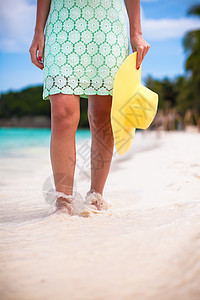 在沙滩上穿着帽子和服装的年轻时装女郎蓝色海滩旅行地平线海洋天堂幸福假期头发女性图片