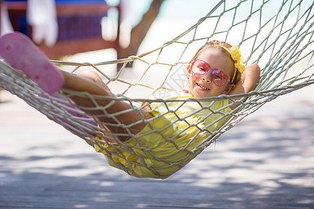 热带度假时可爱的小女孩 在吊吊吊床上放松情感女儿婴儿喜悦海岸线吊床闲暇幸福女性孩子图片