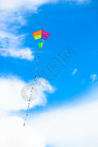 风背景蓝色天空中飘扬着多彩的风筝橙子空气玩具闲暇乐趣活动海滩阳光微风娱乐图片