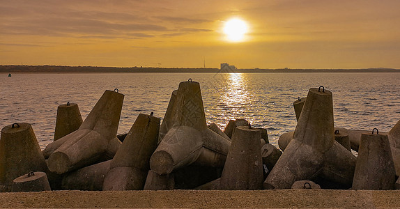 日落在海平端和Swinoujscie市海岸上空 从防波堤看到城市科学技术旅游海洋旅行黄金天空橙子太阳时段图片