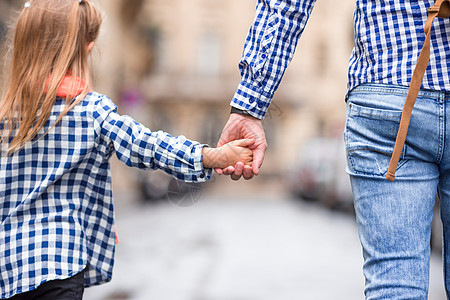 人与儿童双手在欧洲城街头共聚一堂的街道上蓝色旅行乐趣父母男人友谊家庭手指成人生活图片