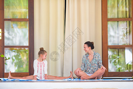 做瑜伽的姑娘快乐的姑娘在户外做瑜伽锻炼姿势平衡父母女孩家庭母亲妈妈成人女性孩子背景