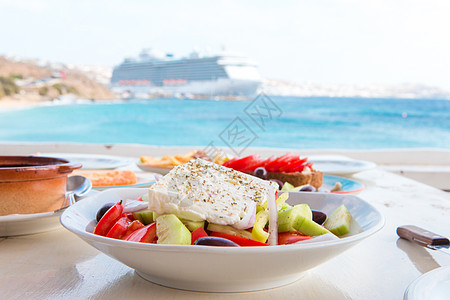 美味新鲜的希腊新沙拉在户外餐厅吃午餐 海边和港口风景美艳蔬菜洋葱玻璃胡椒食物饮食美食草药黄瓜盘子图片
