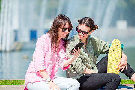 欧洲城市的年轻城市女孩快乐 高加索女人一起在户外玩得尽兴公园生活旅行天气女士旅游指导滑板相机成人图片