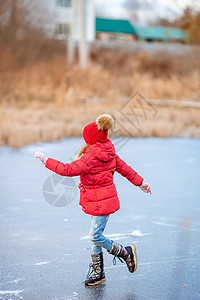 可爱的小女孩在冰场滑冰滑冰场速度教学手套帮助孩子溜冰场女孩爱好喜悦图片