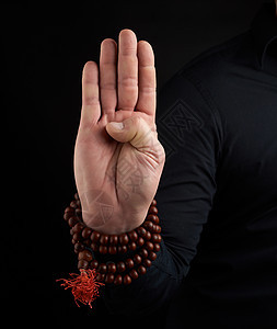 一只成年男子的手在黑暗背景上展示泥巴手腕咒语头脑宗教手指男性身体棕榈男人祷告图片