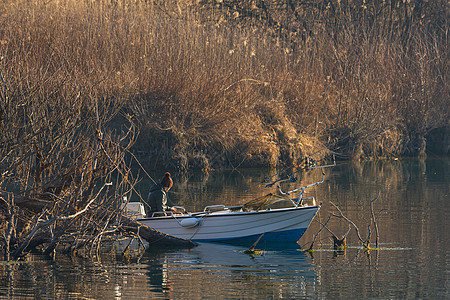 清晨在河边的船上乘船的渔夫池塘地平线传统旅行文化天空钓鱼生活旅游反射图片