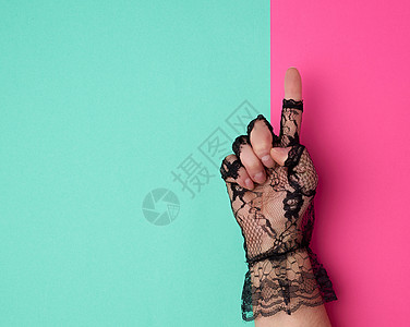魅力女人节在粉红色绿色背景上 戴上黑蕾丝手套背景