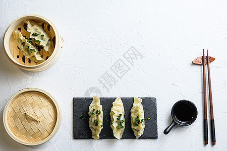 概念中国小吃 中国蒸饺日本饺子或木蒸锅中的饺子小吃 并在黑色石板上加酱油中国传统美食顶视图文本空间图片