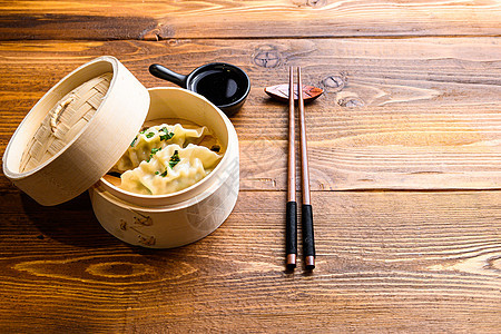 中国小吃 中国蒸饺 中国传统美食概念 在木制蒸锅酱油和筷子侧视图空间中用于文本图片