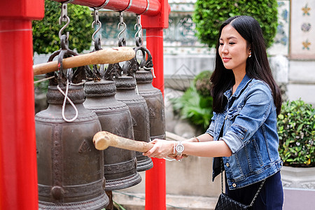 女人在泰国佛教寺庙敲响铃声头发顺口溜宗教学校戒指信仰女士工艺平底锅传统图片