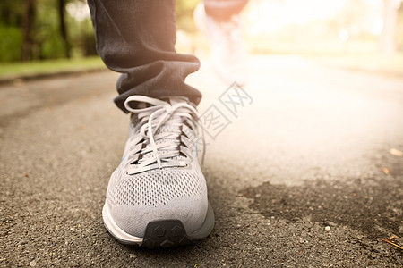 女性穿着运动鞋在中央公园慢跑运动员活动阳光男人耀斑慢跑者跑步日落女士赛跑者图片