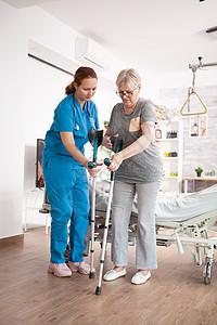 帮助老年妇女在养老院中的照料者助老妇白色擦洗卫生护士女士蓝色病人女性保健照顾者图片