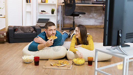 胡子人喝汽苏打水 坐在枕头上做地板夫妻沙发家庭电视女士成人长椅动物筹码男朋友图片