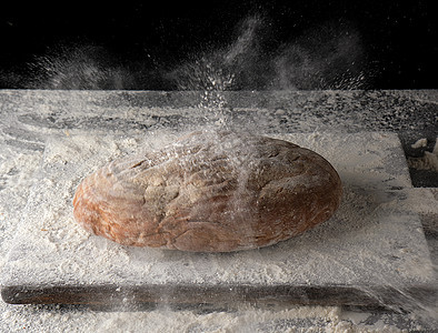白面粉喷洒中烤的奥瓦尔黑麦面包厨房面团营养烹饪桌子面包小麦食物木板黑色图片