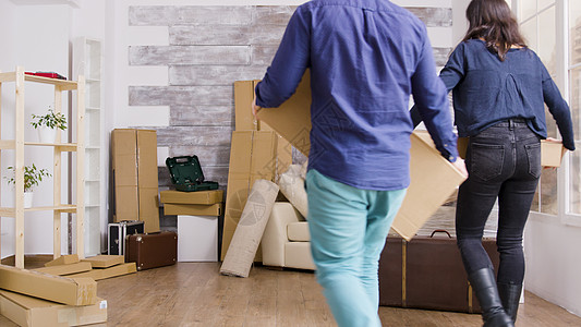 年轻夫妇在新公寓内携带箱箱女性搬迁男性投资夫妻房子房间家庭拥抱盒子图片