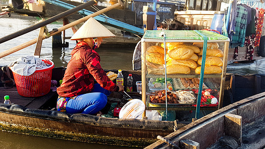 一个街头食品销售商 在木船上出售banh mi图片